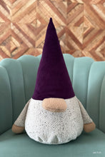 Load image into Gallery viewer, Stuffed gnome with a purple hat on a green couch against a wooden wall.