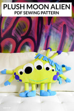 Load image into Gallery viewer, colorful moon alien character stuffed animal on graffiti paining background with text above