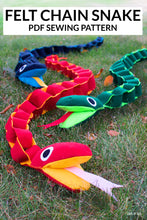 Load image into Gallery viewer, Colorful felt chain snake on grass with &#39;Felt Chain Snake PDF Sewing Pattern&#39; text above.
